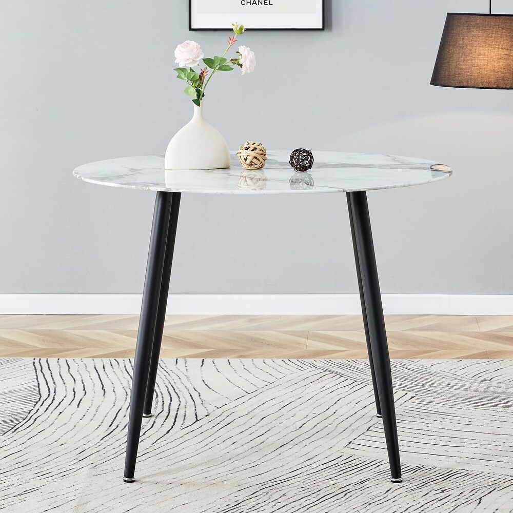 A modern circular dining table with a 0.3 inch thick white imitation marble pattern tabletop and black metal legs