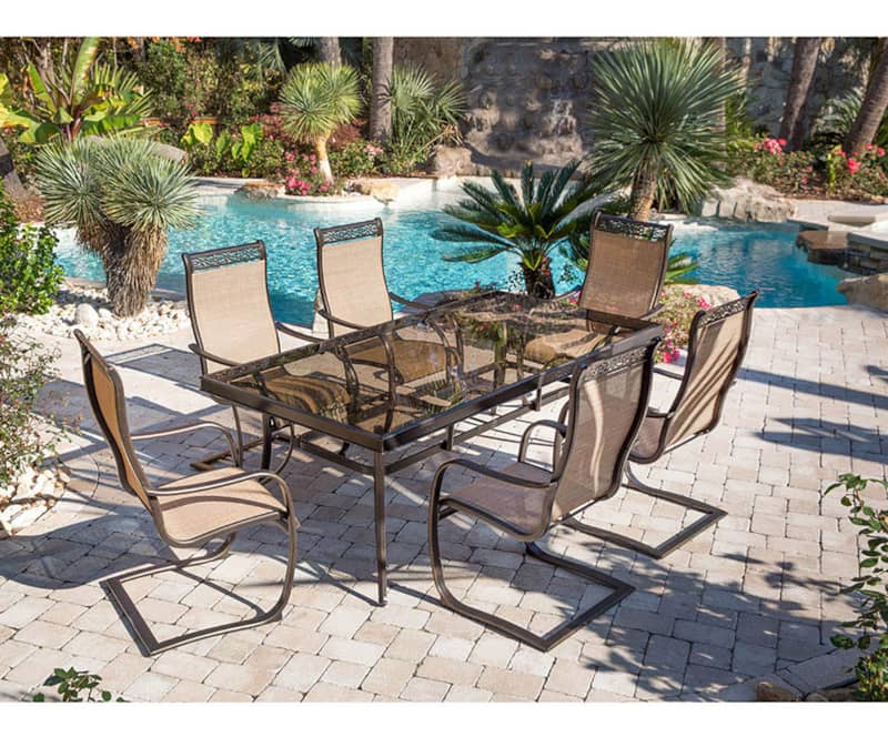 Hanover Monaco 7-Piece Outdoor Dining Set In Tan/Bronze With 6 Spring Sling Chairs， 42 x 84 Glass-Top Table